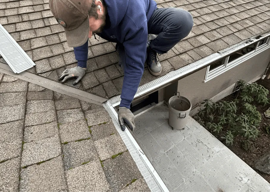 Harrison’s technician carefully fitting micro-mesh gutter guards along a shingle roof